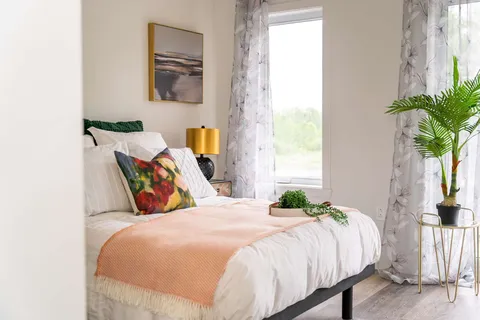 Bedroom with a bed, bedside furniture and a window.