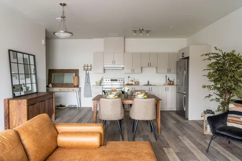 Suite living and dining area with a white kitchen.