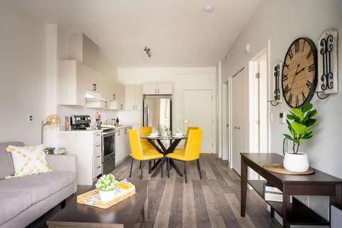 Suite sitting area beside a kitchen and dining table.
