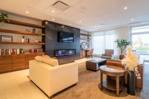 Lobby lounge with sofas, bookshelves and a fireplace.