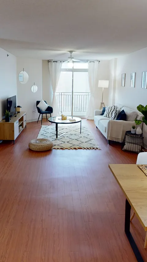 Suite sitting area with a sofa, round table and balcony window.