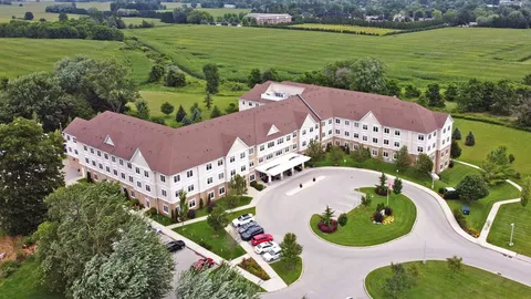Aerial view of the residence and circular driveway beside lawns and fields