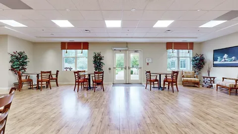 Wooden tables and chairs beside windows and a glass door