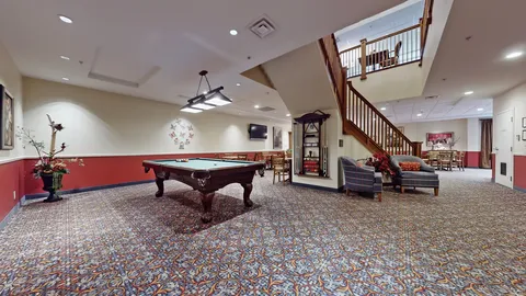 Billiards table beside a staircase and seating area