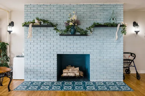 Painted brick fireplace with flowers and plants on the mantel