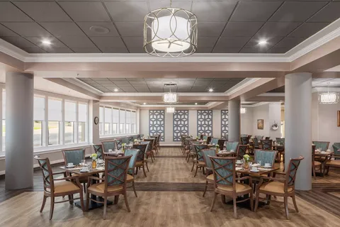 Dining room with tables, upholstered chairs and large windows