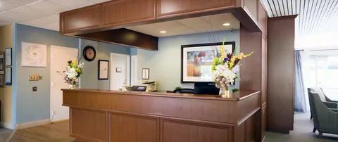 Reception desk with flowers, chairs and framed artwork