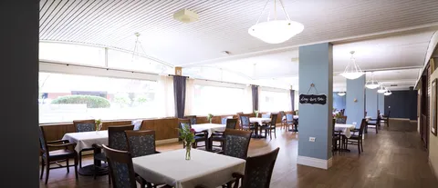 Dining room with tables, blue chairs and large windows
