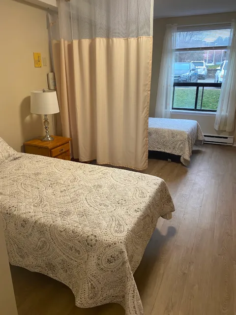 Shared suite with two single beds separated by a curtain.