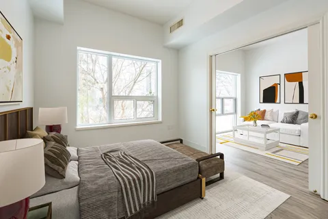 Bedroom with a bed and doorway opening to a living area