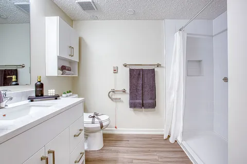 Bathroom with a vanity, toilet and accessible shower.
