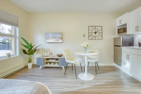 Studio dining area with a round table and kitchenette.