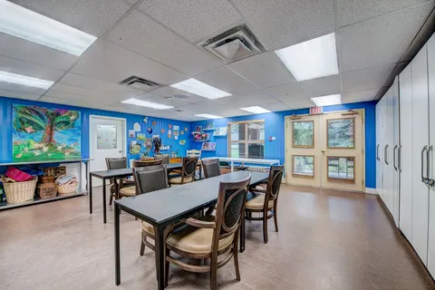 Art studio with worktables, chairs, sinks and storage cabinets.