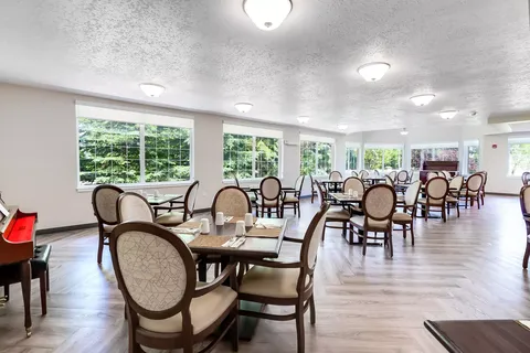 Dining room with set tables and chairs beside large windows