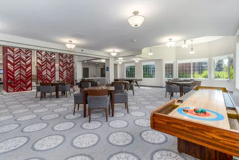Games area with a shuffleboard table and round tables
