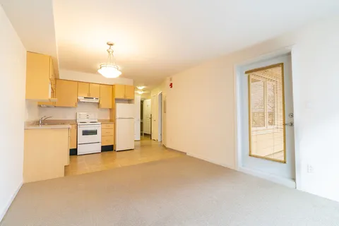 Unfurnished suite living area with a kitchenette and window.