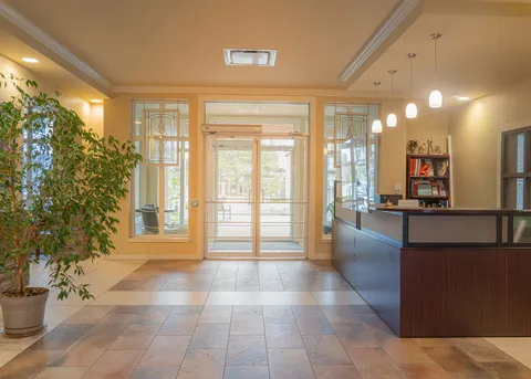 Entrance lobby with tiled floor, glazed doors and a reception counter.