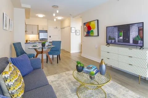 Living room with a sofa, television and a dining table.