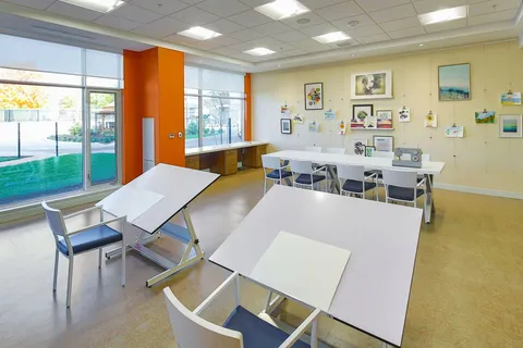 Art studio with work tables and paintings.