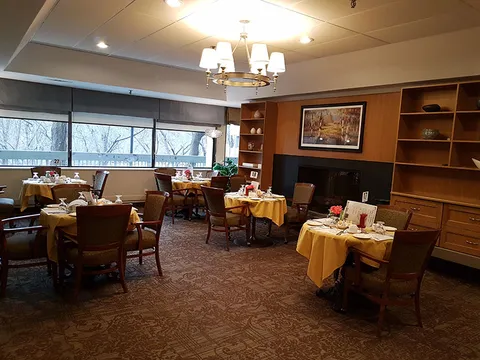 Dining room tables with yellow linens and wooden chairs.
