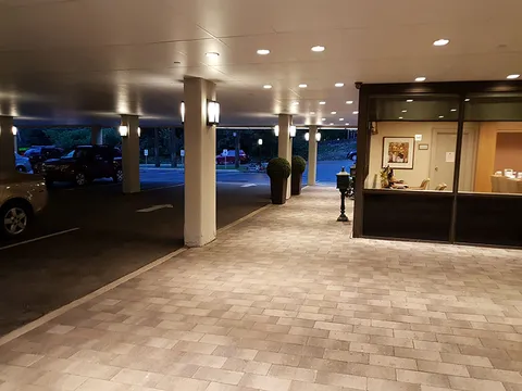 Covered entrance with illuminated windows at night.