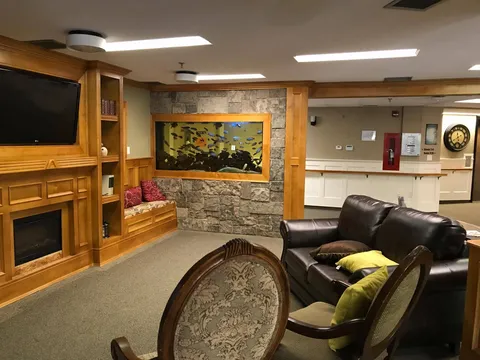 Sitting area with a leather sofa, fireplace, television and wall aquarium