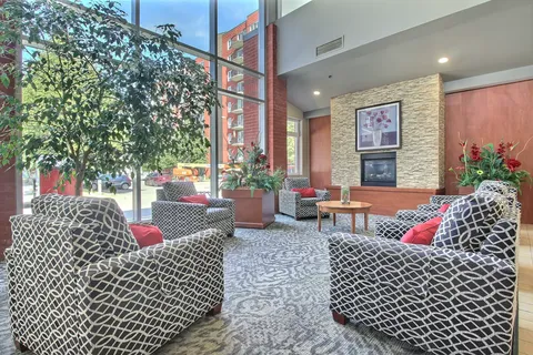 Seating area with patterned chairs, a fireplace and tall windows