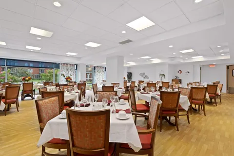 Dining room with white tablecloths and upholstered wooden chairs