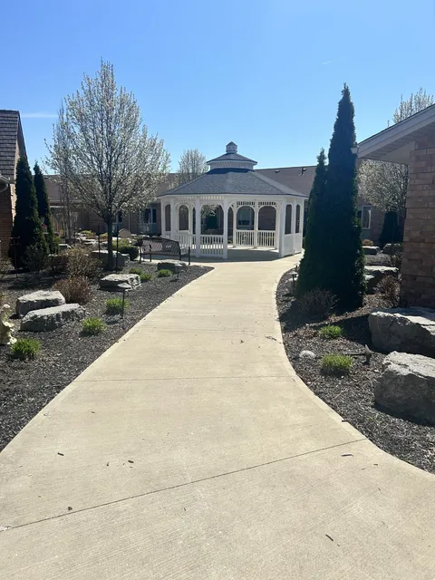 Garden path leading to a white gazebo between residence wings.