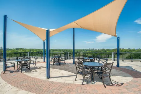 Rooftop terrace with tables, chairs and a fabric shade canopy