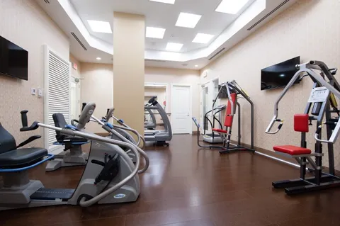 Exercise room with treadmills, elliptical machines and wall-mounted screens