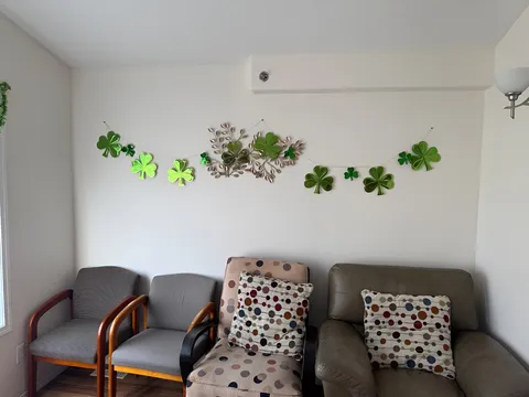 Seating area with two chairs, two armchairs and green wall decorations
