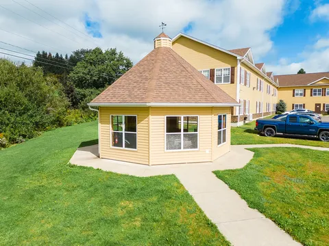 Enclosed yellow gazebo beside a lawn and the residence