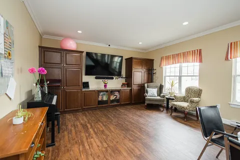 Room with armchairs, a piano and a large dark television