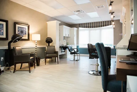 Salon with styling chairs, mirrors and a manicure table.