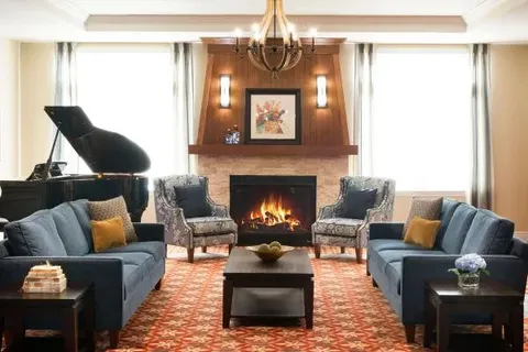 Fireside lounge with sofas, armchairs and a grand piano.