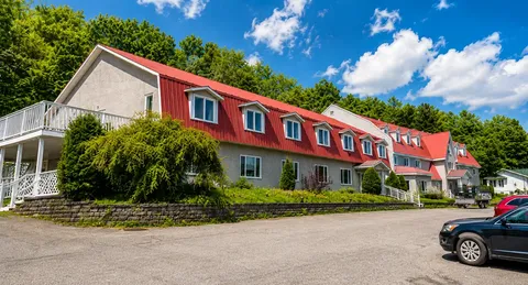 Residence side with a red roof, balconies and shrubs