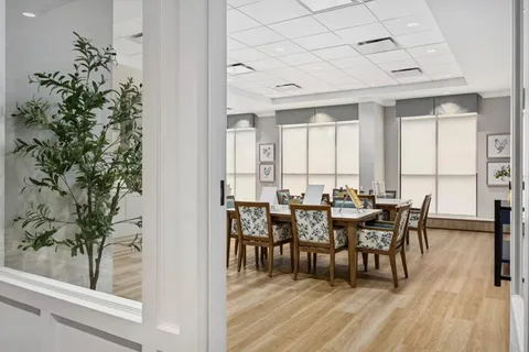 Tables and chairs beside bright cabinets and botanical prints