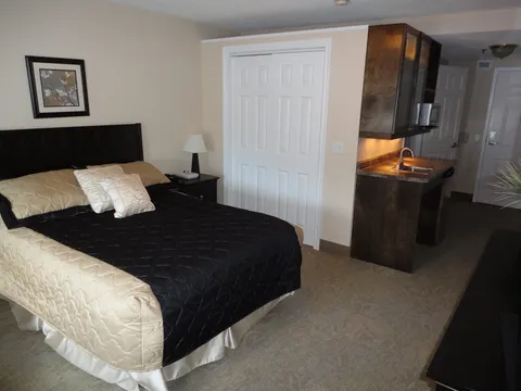 Suite bedroom with a bed, wardrobe and kitchenette.