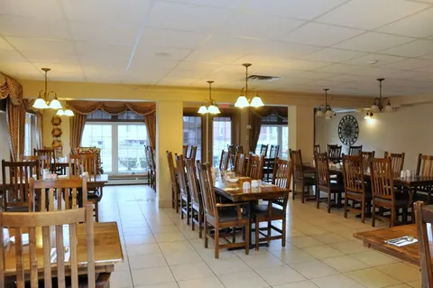 Dining room with wooden chairs, tables and pendant lights