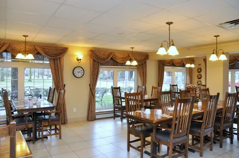 Dining tables beside tall windows and curtains