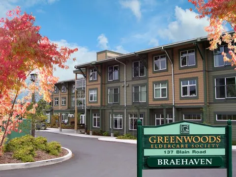 Three-storey residence with autumn trees and a roadside Braehaven sign