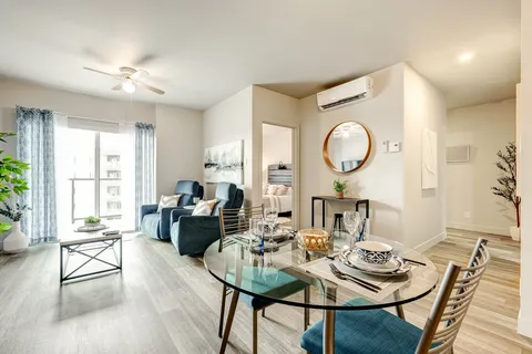 Sitting area with two blue armchairs and a set glass dining table