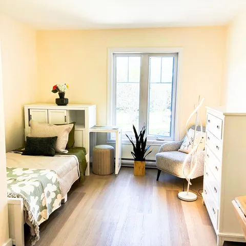 Bedroom with a single bed, white drawers and an armchair