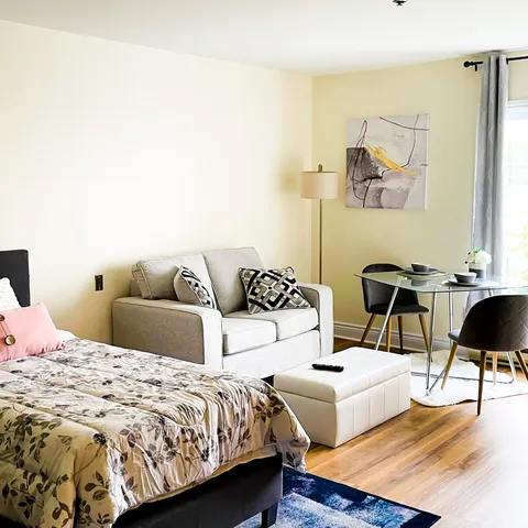 Suite with a double bed, sofa and glass dining table