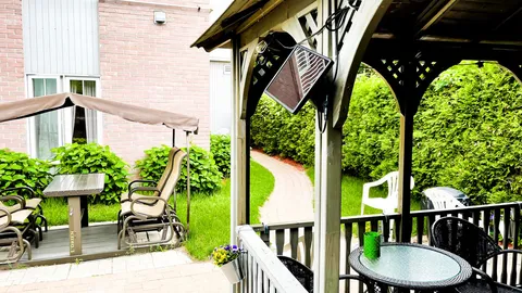 Garden gazebo with seating, a table and a paved path