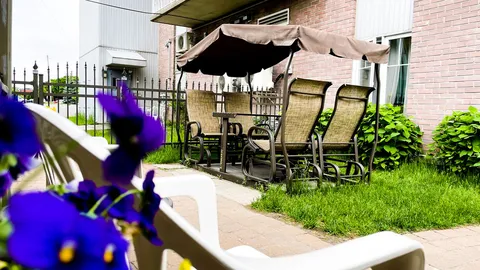 Covered garden seating beside a brick wall and flower beds
