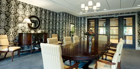 Private dining room with a long table and upholstered chairs.