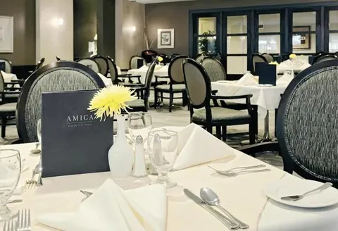 Dining tables set with glassware, cutlery and menus.