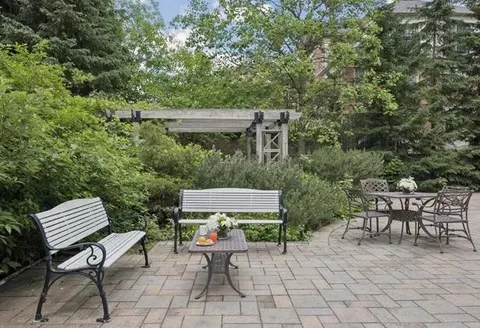 Garden patio with benches, tables and planted borders.